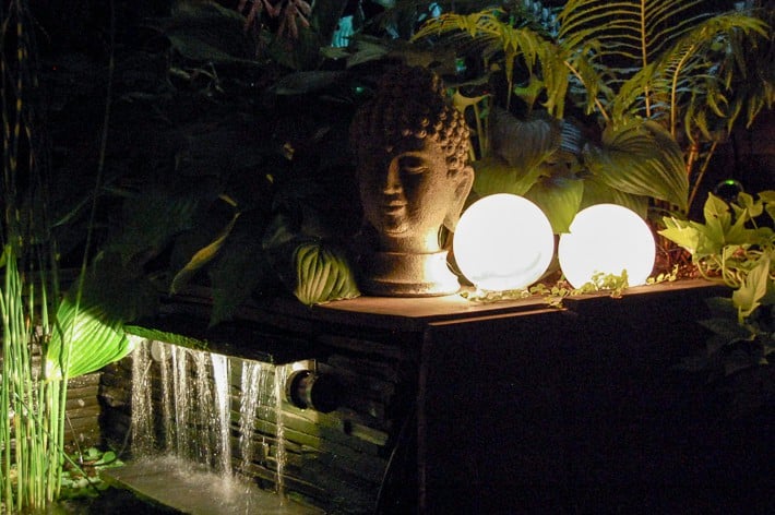 DIY glowing outdoor orbs for backyard behind Buddha head and pond waterfall.