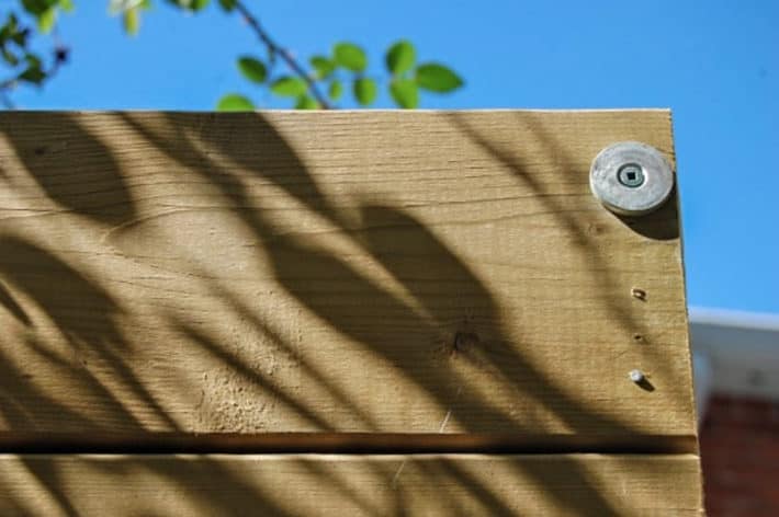 Washer screwed into top of fence gate to act as striker for rare earth magnet.