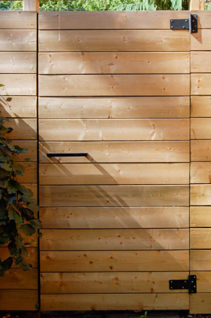 How to DIY magnetic gate latches that are invisible. Modern gate on fence with a simple black Ikea cupboard handle and square black hinges.