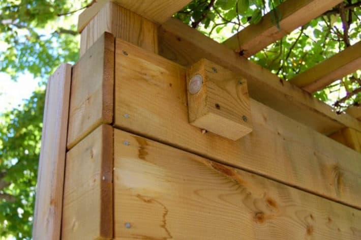 Block of wood screwed into top of arbour to act as a striker for an invisible gate latch.