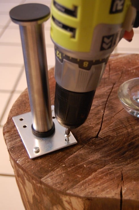 Drilling into stump table to attach legs.