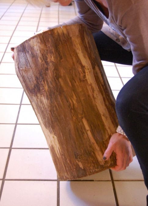 Lifting sanded tree stump table.
