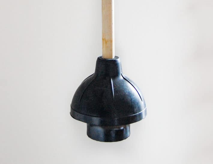 Detailed shot of the flange and bell on a black toilet plunger.