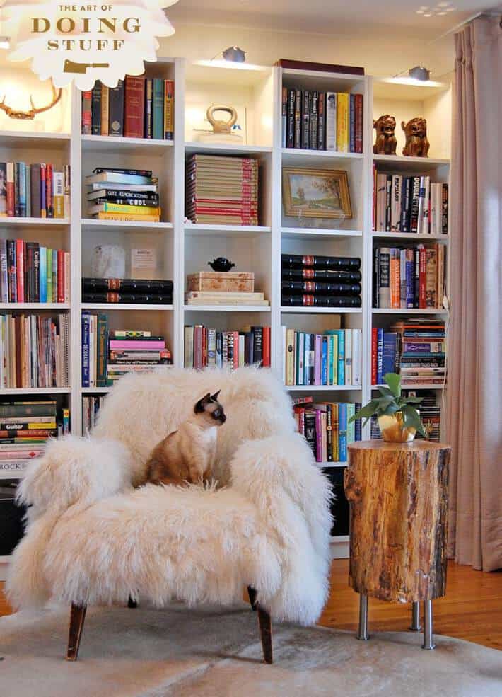 Fluffy chair with Siamese cat beside a DIY stump table.
