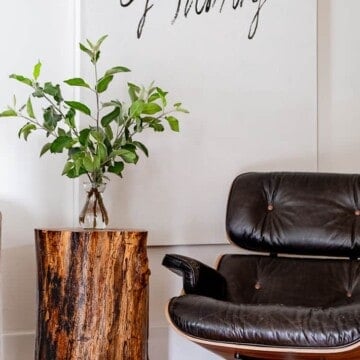 A stump table sits beside an Eames recliner.