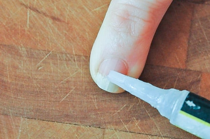 Applying super glue to nail.