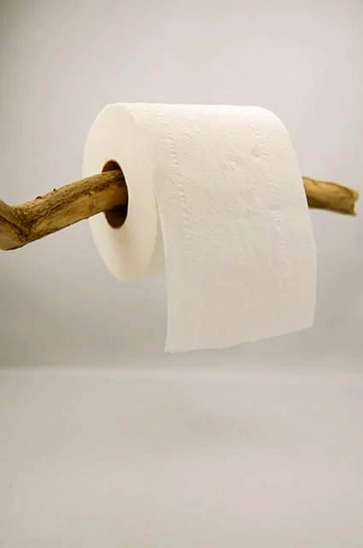 Toilet paper rolling "over" wood stick.