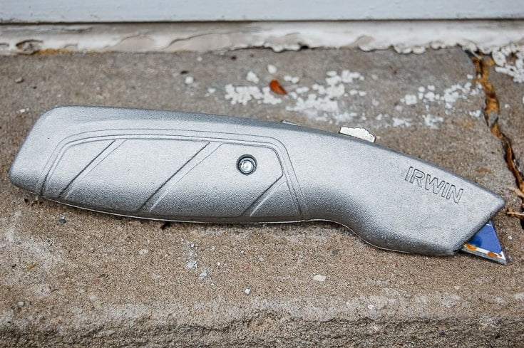 Box cutter on cement windowsill.