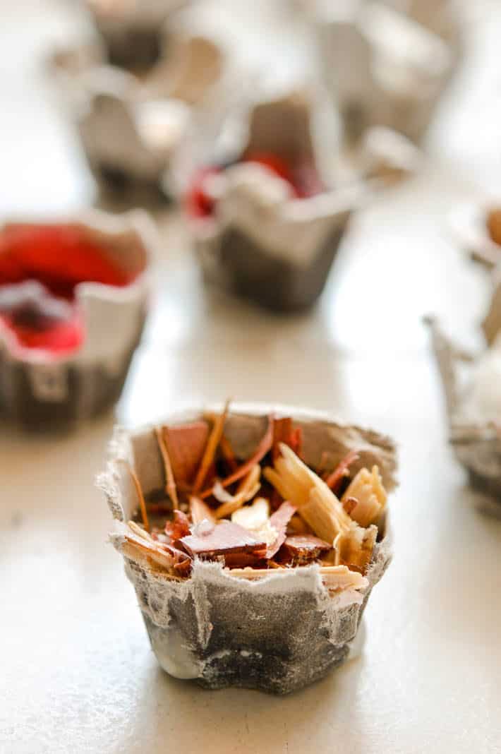 A simple homemade fire starter made with an egg carton, lint, wax and wood chips.