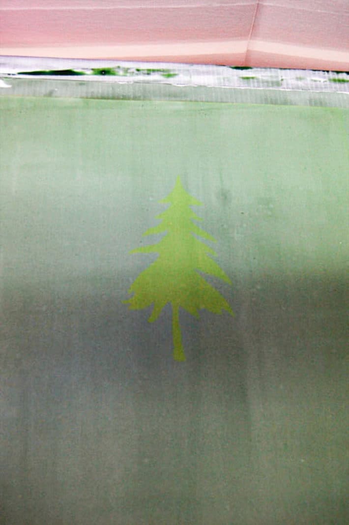 Newly burned screen printing frame with a faint pine tree silhouette.