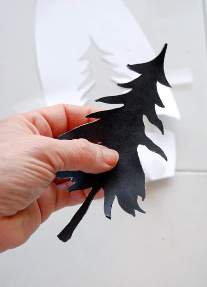 Print of a black pine tree cut away from white printer paper.