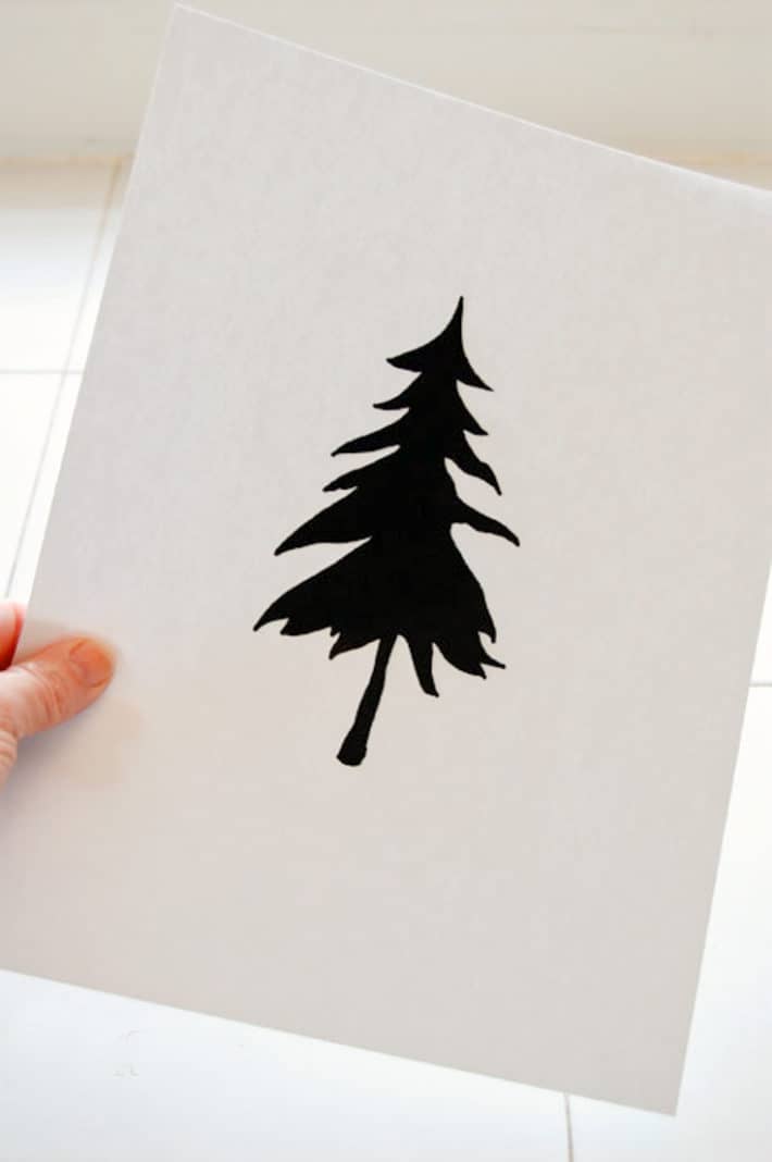 White paper printed with a solid silhouette of a pine tree on it. 