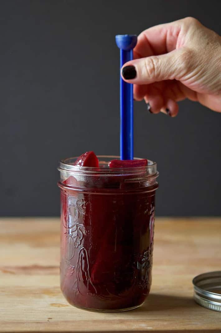 Removing the air bubbles in a mason jar with a plastic stick prior to canning.