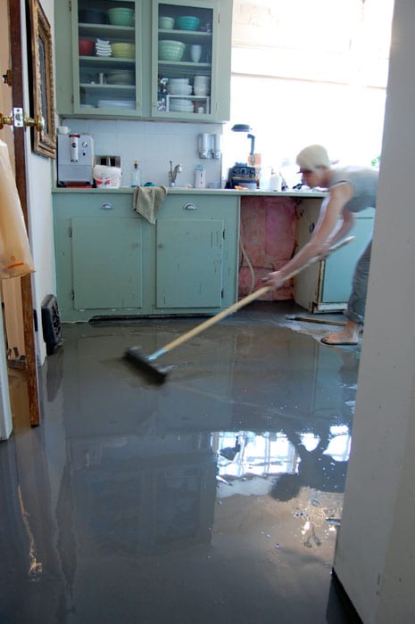 Pulling newly poured self leveling cement into place.