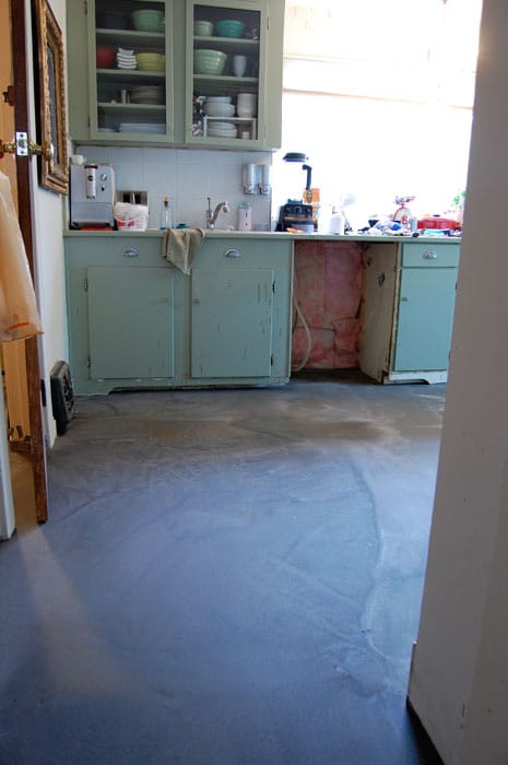 Kitchen in a disaster mid renovation with newly poured flooring.