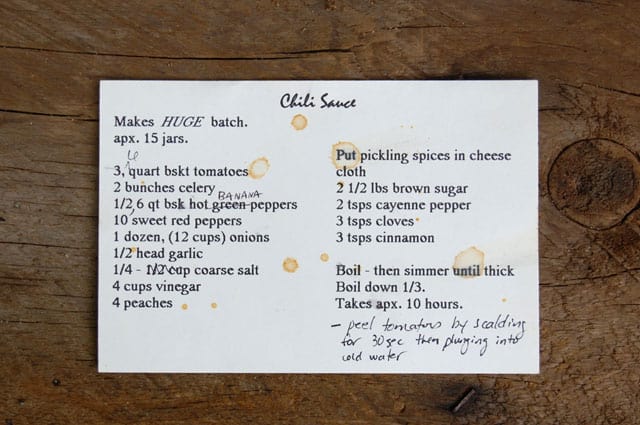 Sauce splattered chili sauce recipe card lying on barnboard table.