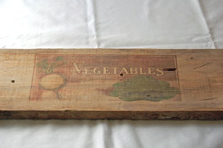 Raw wood with perfect image of the word Vegetables and primitive images of a turnip and cabbage.