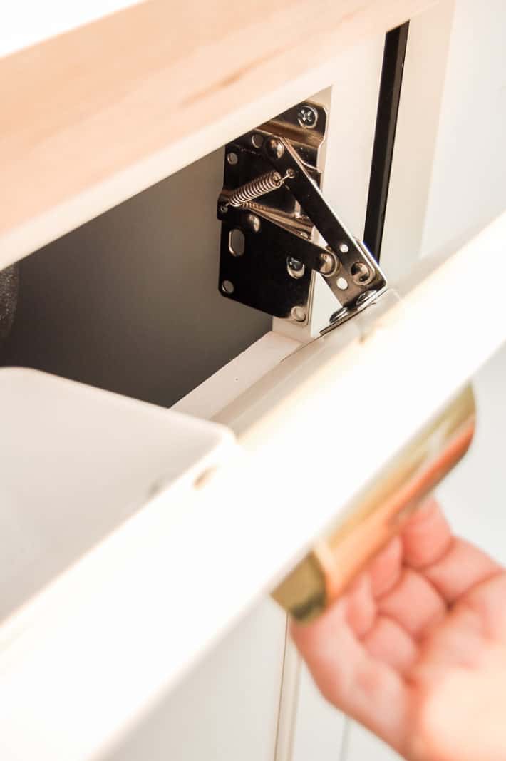 Pulling out a sink drop down drawer fitted with a Rev-a-shelf tip out tray.