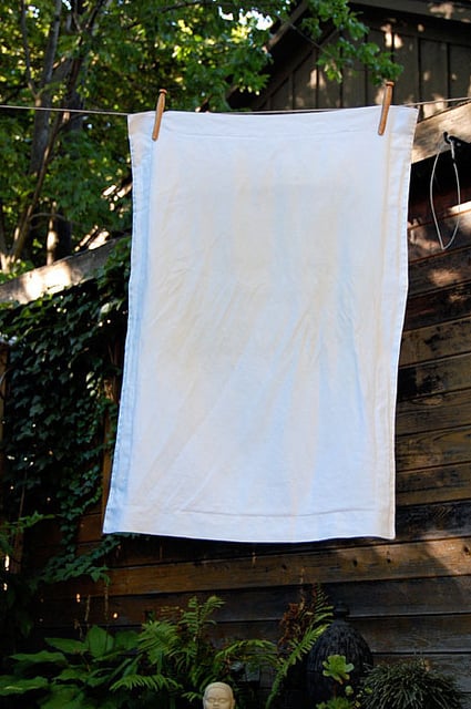 White pillow case hanging on a clothes line.
