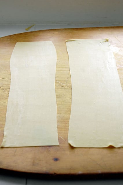 Flat sheets of pasta laid on a wood pizza peel.