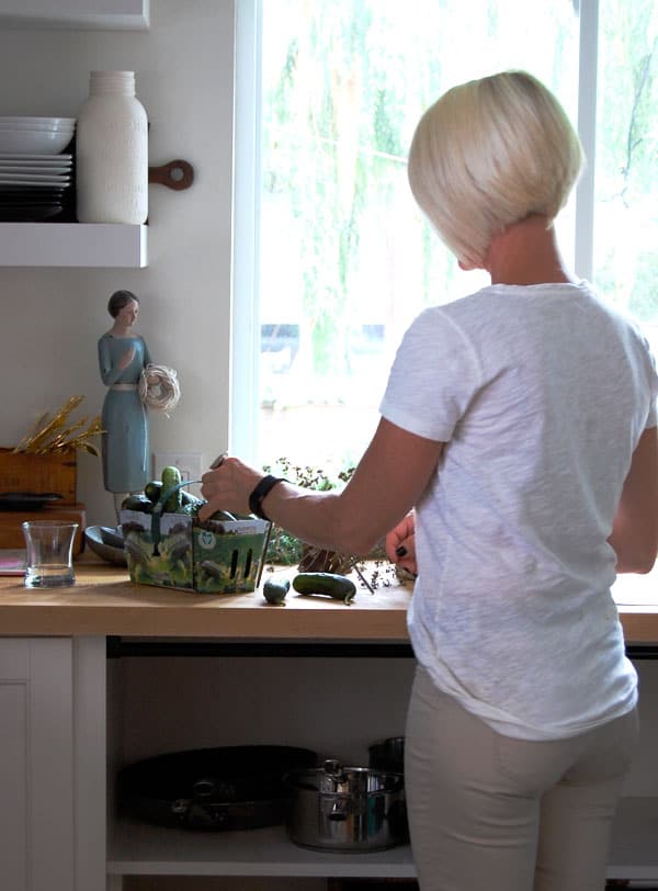 Karen Bertelsen prepping cucumbers at butcher block countertop.