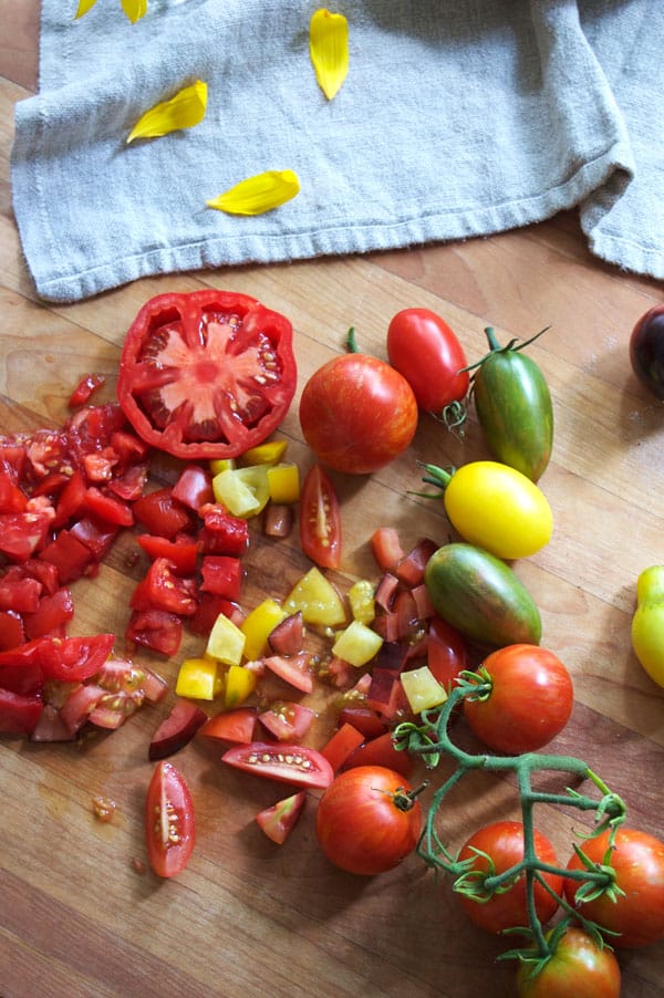 Diced multicolored heirloom tomatoes on a butcher block counter.