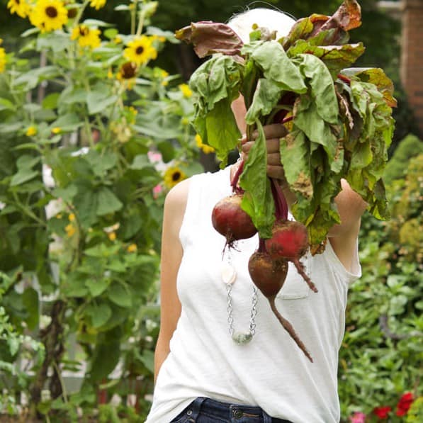 Karen Bertelsen holds out a bunch of beets.