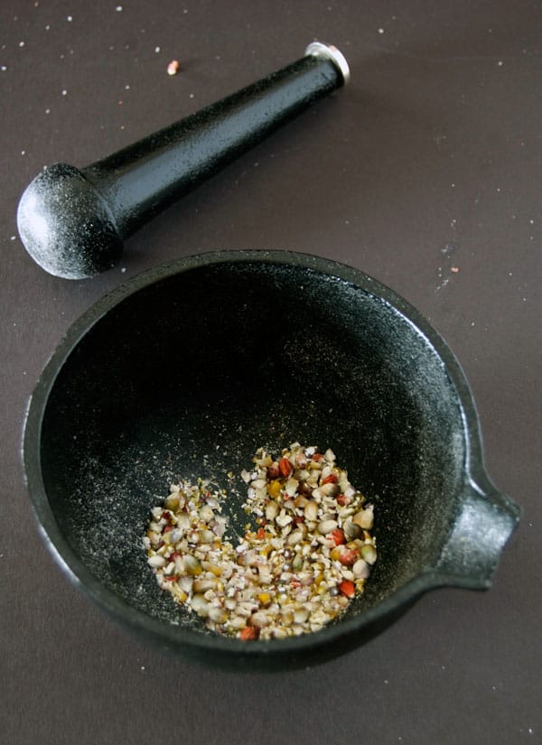 Glass gem corn ground with a cast iron mortar and pestle to test its moisture by weight.