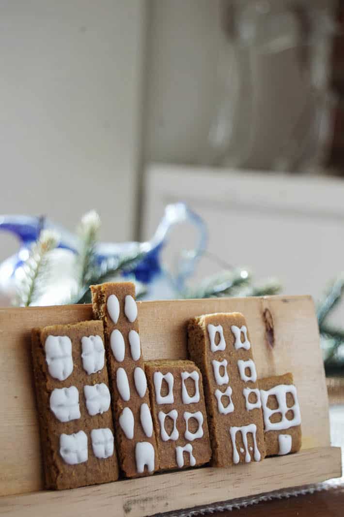 Gingerbread condos sit on a cookie display stand.