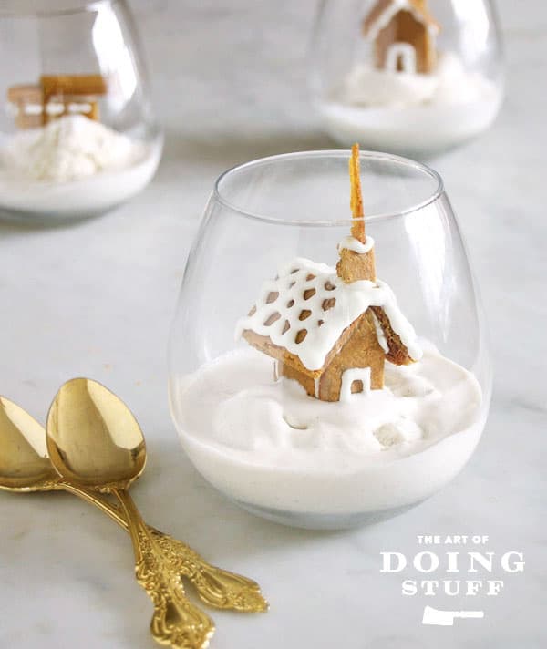 Tiny gingerbread church in a clear glass on a bed of vanilla ice cream for an easy Christmas dessert.