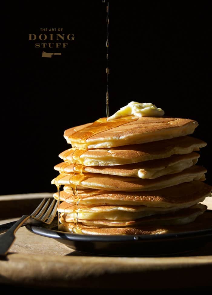 Stack of delicious pancakes dripping with maple syrup.