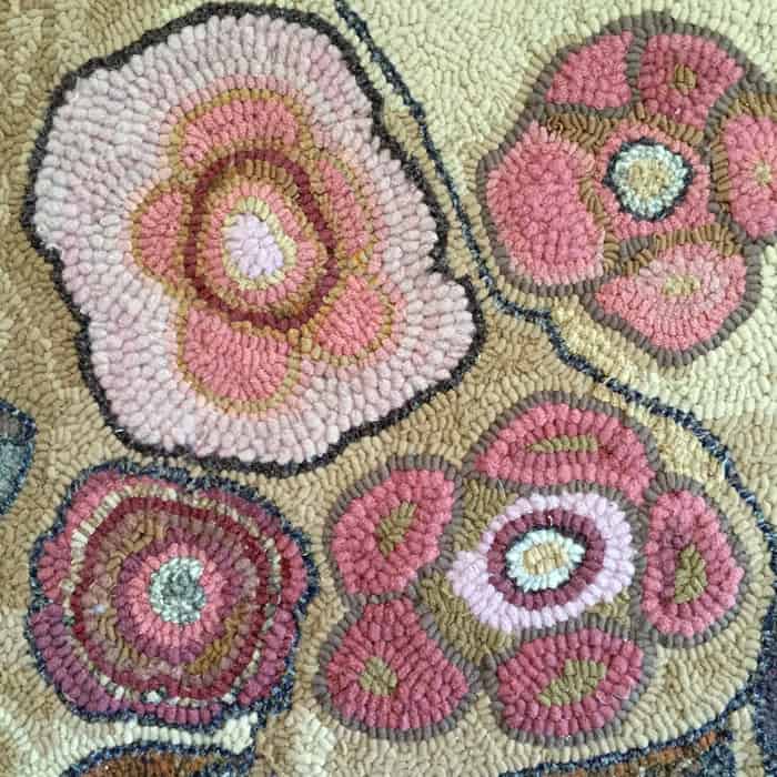 Abstract flowers in traditional rug hooking.