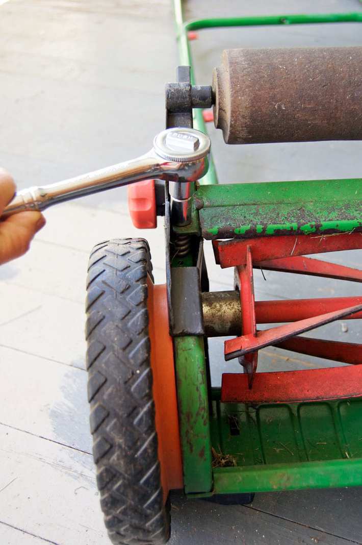 How to sharpen your push mower's blades. Moving the cutting bar closer to the reel blades on a push mower using a ratchet.