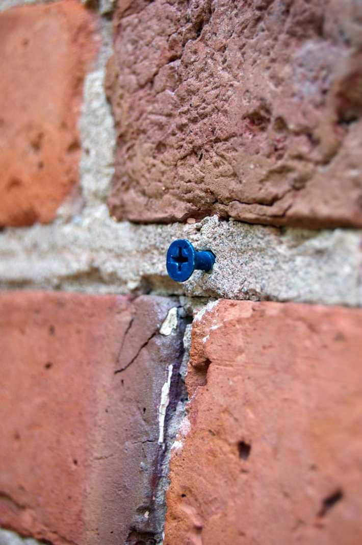 Small blue Tapcon screwed into mortar.