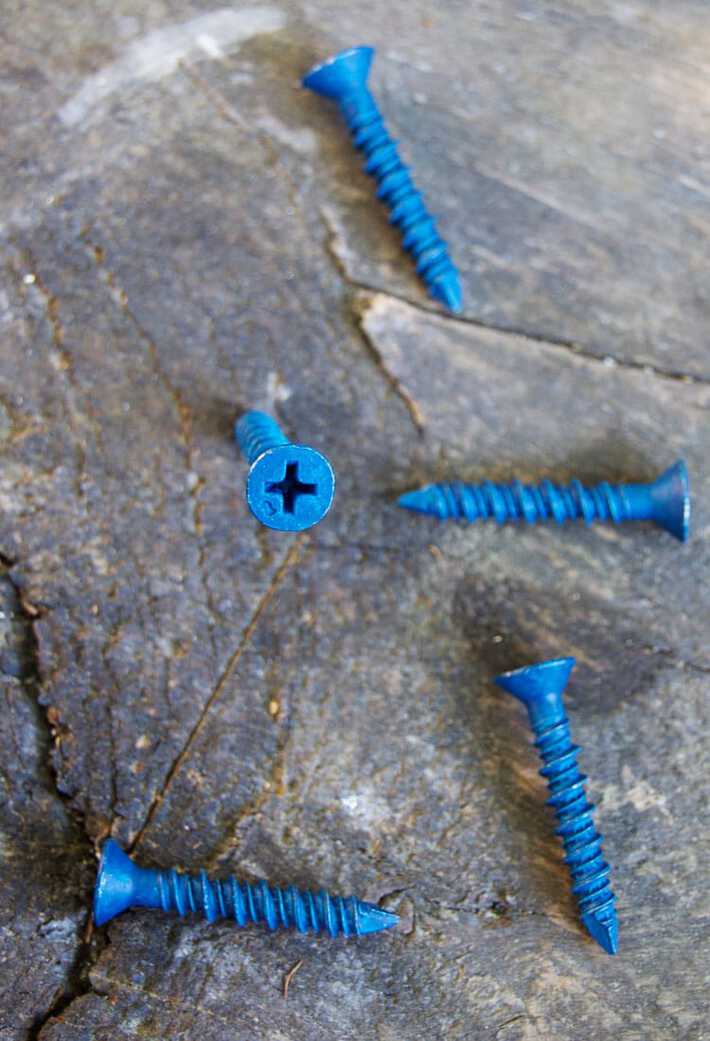 Various blue Tapcon screws laid on wood