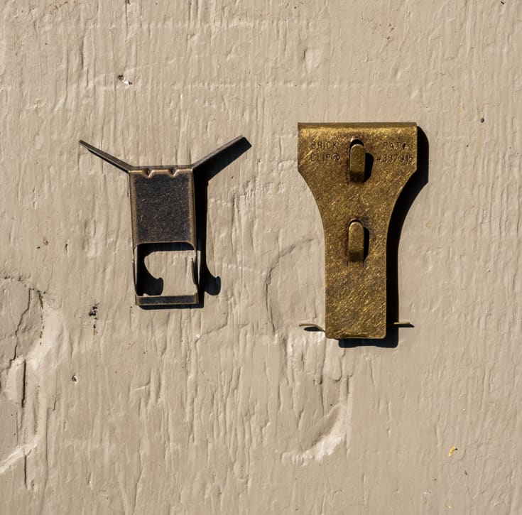 2 styles of brick clips on wood board.