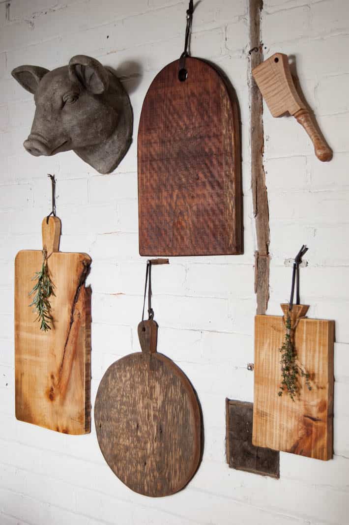 DIY charcuterie boards hang on wall.