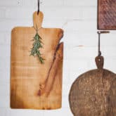 Handmade Wood cheese boards hanging on brick wall.