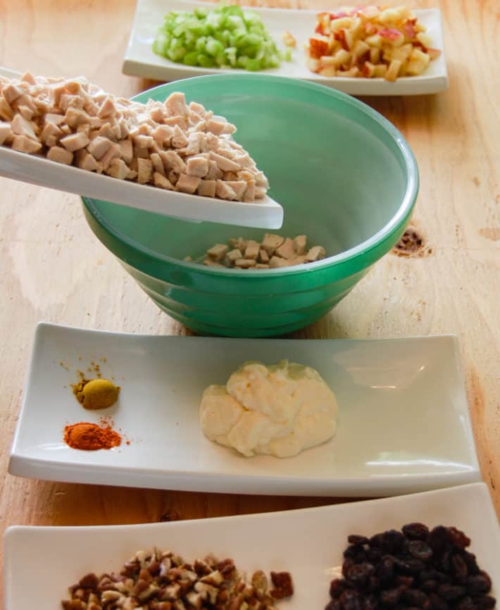 Dice ingredients laid out mise en place, with diced chicken being added to green bowl