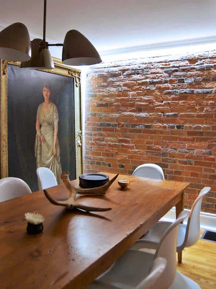 Dining room with brick wall illuminated by LED strip lighting.