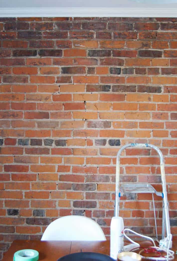 Plain brick wall with a step ladder in front of it prior to installing LED lights.