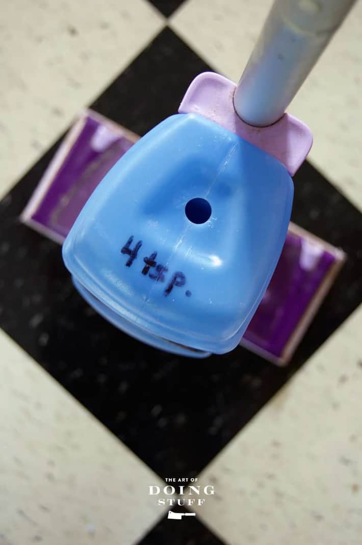 Top of a a Swiffer solution bottle with a hole drilled into it and "4 tsps" written in marker to remind you how much cleaning solution to put in.