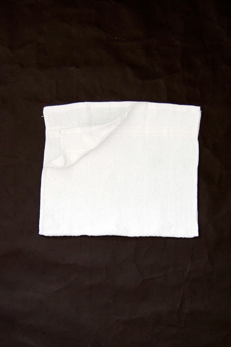 Hand towel folded in half to make a square.