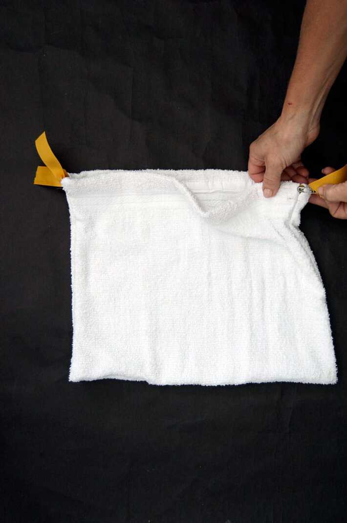 Yellow grosgrain ribbon being fed through the top of a salad bag casing with a safety pin.