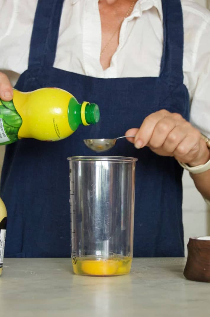 Pouring out 1 tablespoon of lemon juice for mayo.