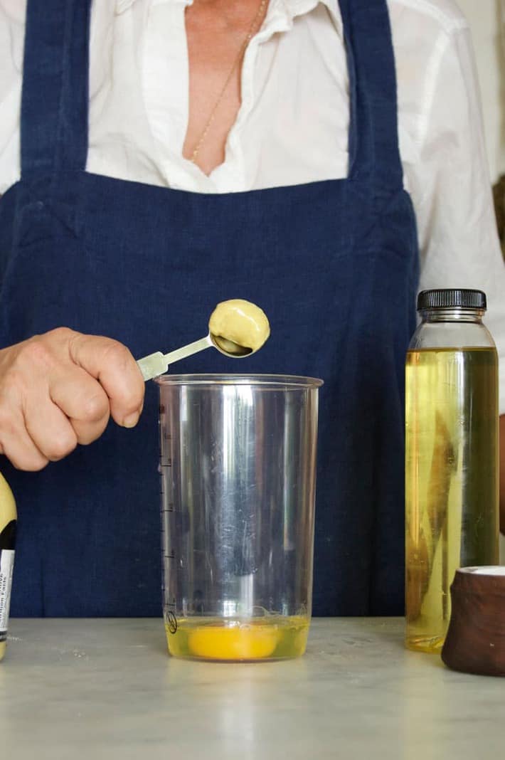 A healthy teaspoon being tapped into jar with an egg.