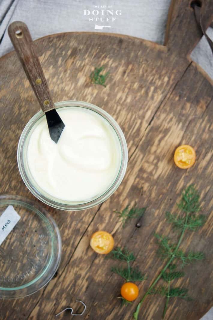 Mayonnaise from scratch in a glass Weck jar on wood cutting board.