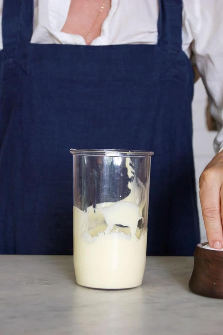 Adding a pinch of salt to homemade mayo.