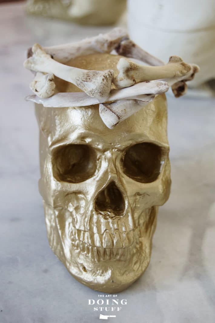 Gold skull topped with a homemade crown made of chicken bones for Halloween.
