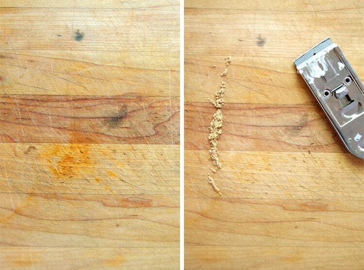 Using a window scraper to remove surface stains from butcher block.